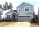 Charming two-story home featuring stone accents, a two-car garage, and a well-manicured lawn at 9842 Quercus Ln, Huntersville, NC 28078