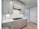 A bright kitchen features gray cabinets, stainless steel appliances, and a gas range stove with hood vent at 9842 Quercus Ln, Huntersville, NC 28078