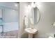 Bright powder room featuring pedestal sink, decorative mirror, and modern lighting at 9842 Quercus Ln, Huntersville, NC 28078