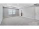 Large bedroom with tray ceiling, neutral carpeting, and a doorway to the bathroom at 9934 Cask Way, Huntersville, NC 28078