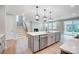 Open concept kitchen features an island with sink, stainless dishwasher, stairs and a fireplace at 9934 Cask Way, Huntersville, NC 28078