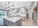 New kitchen features light gray cabinets, stainless appliances, a pantry and an island with sink and pendant lighting at 9934 Cask Way, Huntersville, NC 28078