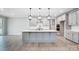 New kitchen features an island with pendant lighting, stainless appliances and light gray cabinets and flooring at 9934 Cask Way, Huntersville, NC 28078