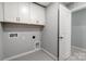 This laundry area features white cabinets, utility hookups, and gray paint for a clean aesthetic at 9934 Cask Way, Huntersville, NC 28078