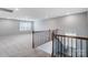 Upstairs loft area boasts neutral carpeting, multiple windows, and wrought iron railing at 9934 Cask Way, Huntersville, NC 28078