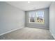Inviting bedroom with neutral walls and carpeting, illuminated by a window overlooking the neighborhood at 9957 Cask Way, Huntersville, NC 28078