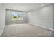 Bright bedroom featuring a large window and plush carpeting, creating a cozy and inviting space at 9957 Cask Way, Huntersville, NC 28078