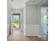 Bright foyer with wood floors, white wainscoting and stone front entrance in view at 9957 Cask Way, Huntersville, NC 28078