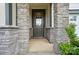 Inviting front entrance with stone pillars and gray front door with glass pane at 9957 Cask Way, Huntersville, NC 28078