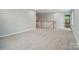 Spacious hallway area with carpeting and wood banister, seamlessly connecting different areas of the home at 9957 Cask Way, Huntersville, NC 28078