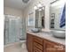Well-lit bathroom featuring a double sink vanity, modern fixtures, and a glass-enclosed shower at 12848 Mustang Dr, Midland, NC 28107