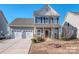 Charming two-story home featuring a two-car garage, well-maintained lawn, and inviting front entrance at 12848 Mustang Dr, Midland, NC 28107