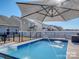 Inviting backyard pool with fountain features and an umbrella, perfect for summer relaxation and entertainment at 12848 Mustang Dr, Midland, NC 28107