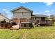 Back of the house showing brick and siding with hot tub and wooden deck and grassy yard at 1308 Gaston Way, Dallas, NC 28034