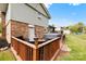 Back of the house showing brick and siding with hot tub and wooden deck with railing at 1308 Gaston Way, Dallas, NC 28034