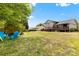 Spacious grassy backyard with blue Adirondack chairs and wooden shed with house and decks in background at 1308 Gaston Way, Dallas, NC 28034