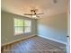 Bright bedroom featuring a ceiling fan, window with wooded views, and hardwood floors at 154 Carters Farm Dr, Statesville, NC 28625