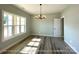 Elegant dining room featuring wood-look floors, neutral walls, a modern light fixture, and natural light at 154 Carters Farm Dr, Statesville, NC 28625