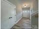 Bright entryway featuring wood-look floors, neutral walls, modern light fixture, and paneled doors, exuding style at 154 Carters Farm Dr, Statesville, NC 28625