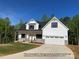 Inviting two-story home featuring a two car garage, black shutters, stone accents, and an immaculate lawn at 154 Carters Farm Dr, Statesville, NC 28625