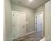 Hallway featuring a stylish gray wall and light wood-look floors with white doors at 154 Carters Farm Dr, Statesville, NC 28625