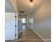Bright hallway featuring wood-look floors, neutral walls, and white trim, creating a seamless, stylish transition at 154 Carters Farm Dr, Statesville, NC 28625