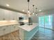 Modern kitchen with white cabinets, stainless steel appliances, an island with a sink, and access to the deck at 154 Carters Farm Dr, Statesville, NC 28625