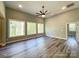 Bright living room featuring wood floors, large windows offering outdoor views, and a modern ceiling fan at 154 Carters Farm Dr, Statesville, NC 28625