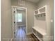 Functional mudroom featuring built-in bench with cubbies, hooks, and ample storage space leading to the outdoors at 154 Carters Farm Dr, Statesville, NC 28625