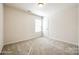 Carpeted bedroom with large window and white door, offering ample space and natural light at 1929 Shorthorn St, Charlotte, NC 28213