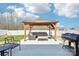 Backyard patio includes stylish outdoor seating, a grill, and lush landscaping under a bright sky at 2027 Redstone Dr, York, SC 29745