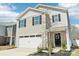 Charming two-story home with a well-maintained lawn, attached garage, and a welcoming front entrance at 2027 Redstone Dr, York, SC 29745