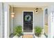 A close-up shot of the front door, adorned with a floral wreath and flanked by lush green plants at 2027 Redstone Dr, York, SC 29745