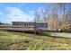Backyard featuring a large deck, grassy area, and shed with a wooded backdrop at 2390 Old Wilkesboro Rd, Statesville, NC 28625