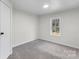 Cozy bedroom with neutral walls, gray carpet and a window for natural lighting at 2390 Old Wilkesboro Rd, Statesville, NC 28625