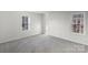 Bright bedroom featuring plush gray carpet and two windows providing natural light at 2390 Old Wilkesboro Rd, Statesville, NC 28625