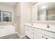 Bathroom featuring a large soaking tub, double vanity, and picture window with bright light at 2514 Waters Vista Cir, Charlotte, NC 28213