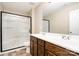 Bright bathroom with double sink vanity and walk-in shower featuring dark wood cabinets at 2514 Waters Vista Cir, Charlotte, NC 28213