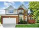 Charming two-story brick home featuring a two-car garage and well-manicured front lawn at 2514 Waters Vista Cir, Charlotte, NC 28213