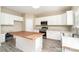 Eat-in kitchen with white cabinets, stainless appliances, butcher block island, and wood-look tile floors at 2514 Waters Vista Cir, Charlotte, NC 28213