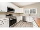 Updated kitchen with white cabinets, stainless appliances, granite countertops, and tile flooring at 2514 Waters Vista Cir, Charlotte, NC 28213