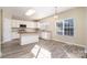 Eat-in kitchen boasts white cabinets, stainless appliances, granite counters, an island, and tile floors at 2514 Waters Vista Cir, Charlotte, NC 28213
