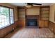 Living room featuring a brick fireplace, built-in shelving, and wood paneling at 275 Ned Williams Rd, Kershaw, SC 29067