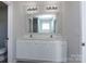 Bathroom featuring double sink vanity with framed mirror and chrome fixtures at 3308 Lemongrass Ln, Charlotte, NC 28214
