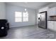 Bright dining area featuring modern lighting, gray wood flooring, and stainless steel refrigerator at 3308 Lemongrass Ln, Charlotte, NC 28214