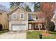 Charming two-story home featuring stone accents, tan siding and an attached two-car garage in a well-manicured yard at 3308 Lemongrass Ln, Charlotte, NC 28214