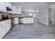 Modern kitchen featuring stainless steel appliances, granite countertops, white cabinets, and gray wood floors at 3308 Lemongrass Ln, Charlotte, NC 28214