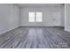 Bright living room featuring modern gray wood flooring, neutral walls and natural lighting at 3308 Lemongrass Ln, Charlotte, NC 28214