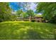 A well-maintained brick house with a chimney overlooks a large, verdant backyard at 3330 Foxcroft Rd, Charlotte, NC 28211