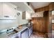 Efficient kitchen featuring stainless steel countertops and cabinetry, with parquet flooring and wood paneling at 3330 Foxcroft Rd, Charlotte, NC 28211